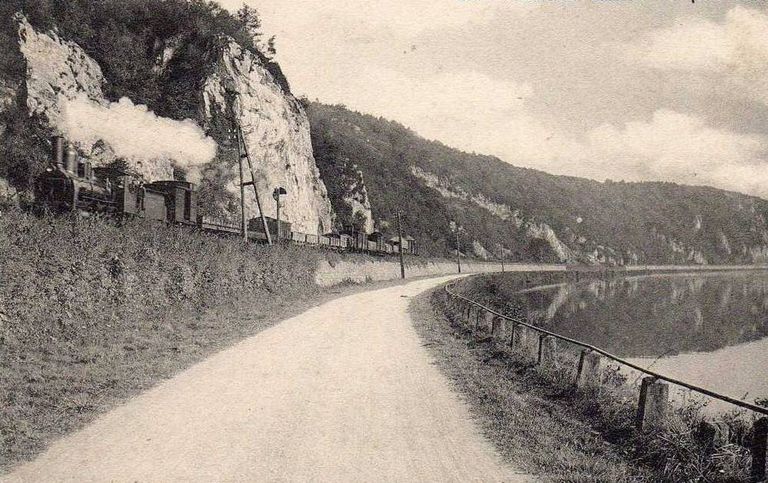 Le train arrive de Waulsort en longeant la Meuse pour arriver à Hastière. D'après une ancienne carte postale.