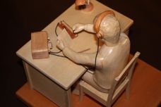 Sculpture d'une scène réaliste : un télégraphiste assis à son bureau en train de travailler (sculpté en tilleul, hêtre, frêne). Mobilier et personnage réalistes