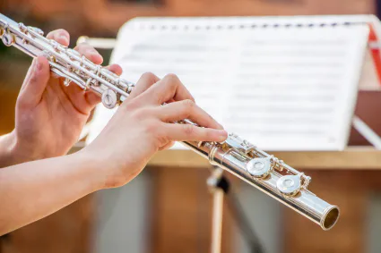 Fille joue flute flute dans mains du musicien lors execution piece musicale