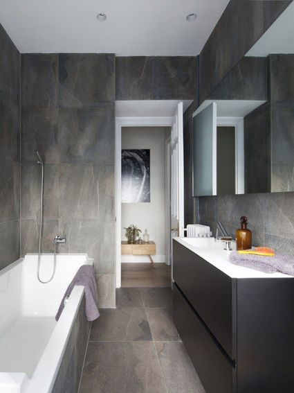 Salle bains moderne carrelage mural sol gris baignoire blanche longue meuble vasque bois noir
