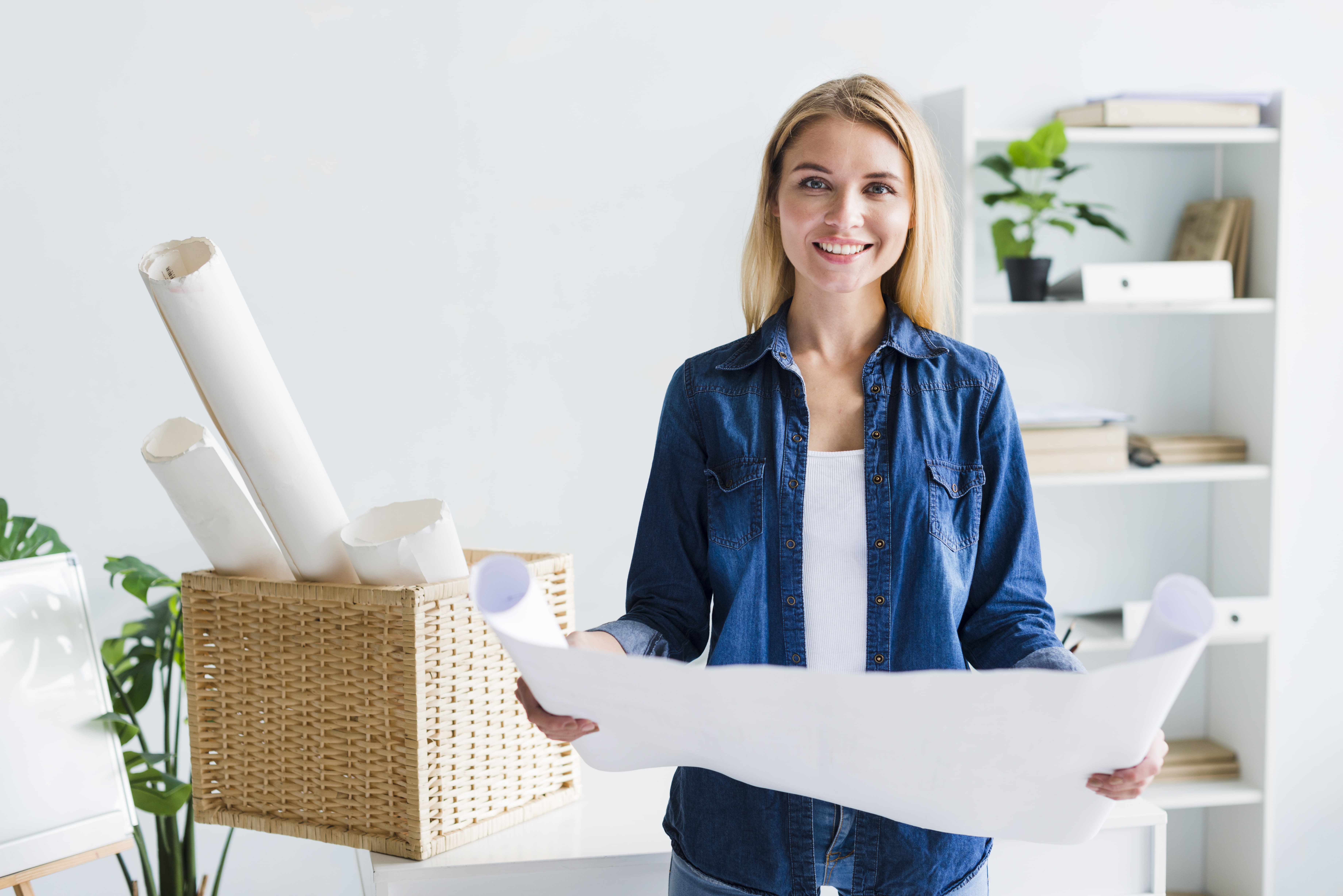 Souriant-designer-femme-blonde-grande-feuille-papier-deroulee-min