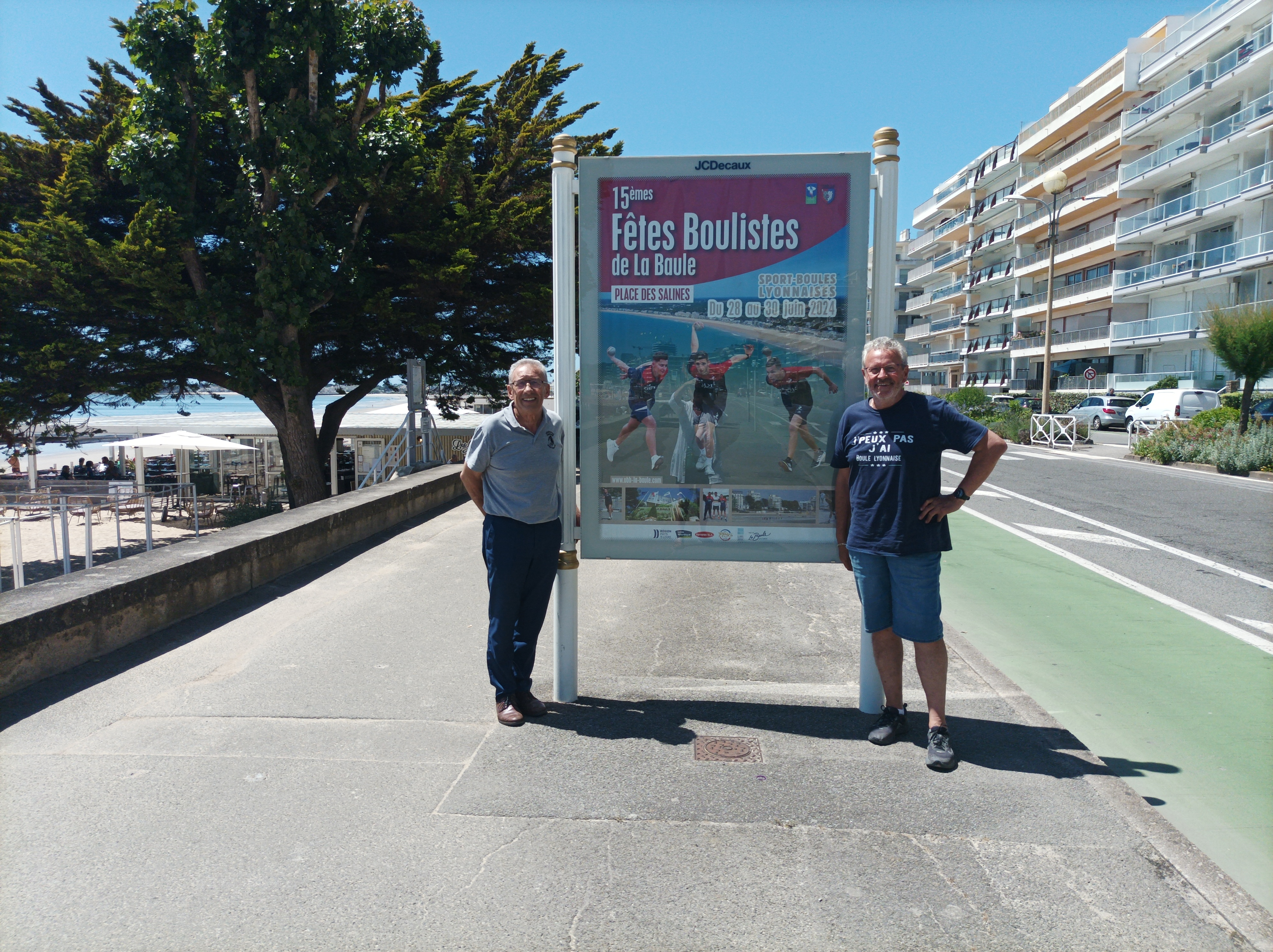 Bernard-DAUBARD-avec-Herve-ALBALADEJO-devant-un-panneau-publicitaire-des-15emes-fetes-boulistes-sur-la-promenade-de-mer-de-LA-BAULE