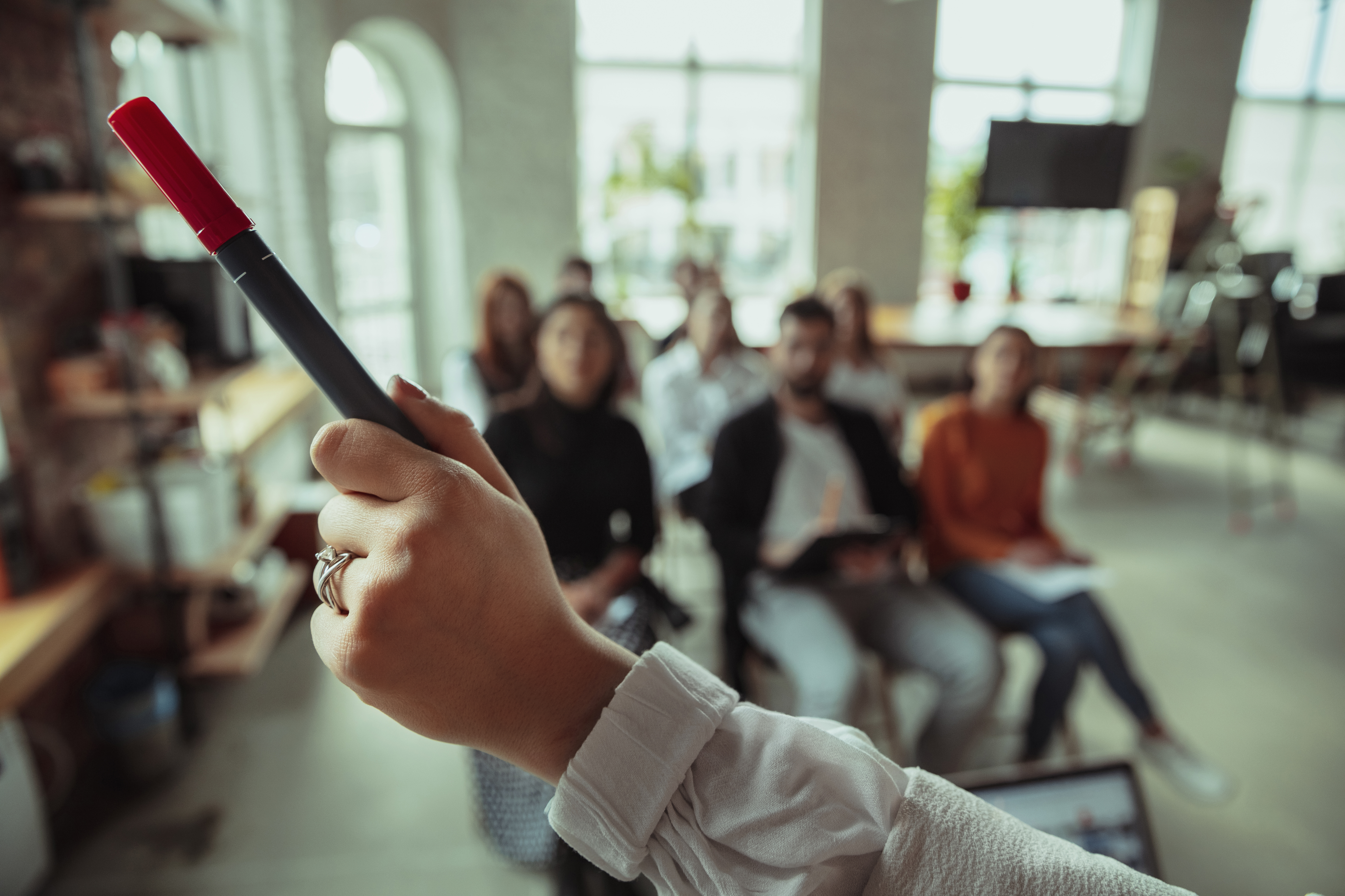 Female muslim speaker giving presentation hall workshop audience conference hall close up pointing hand with marker conference event training education diversity inclusive concept