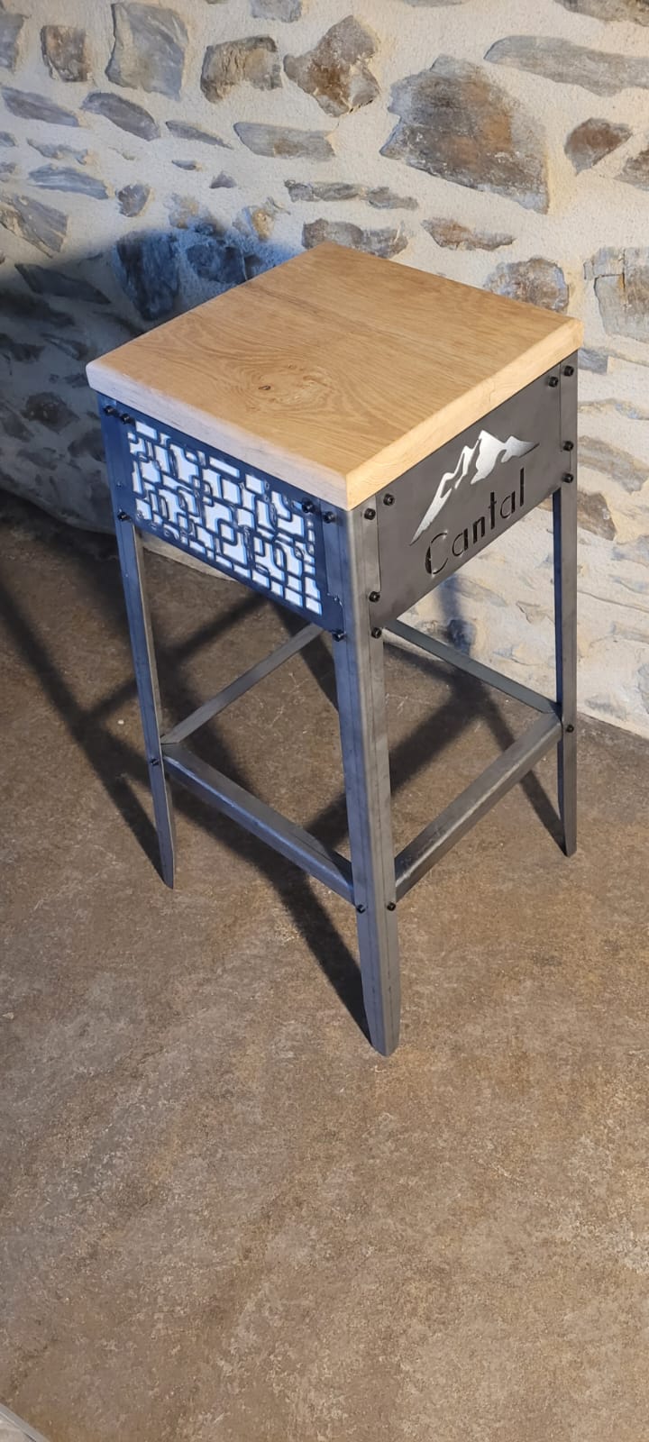 Exemple de personnalisation avancée d'un tabouret design, avec un logo 'Cantal' et un motif géométrique décoratif découpé sur le côté.
