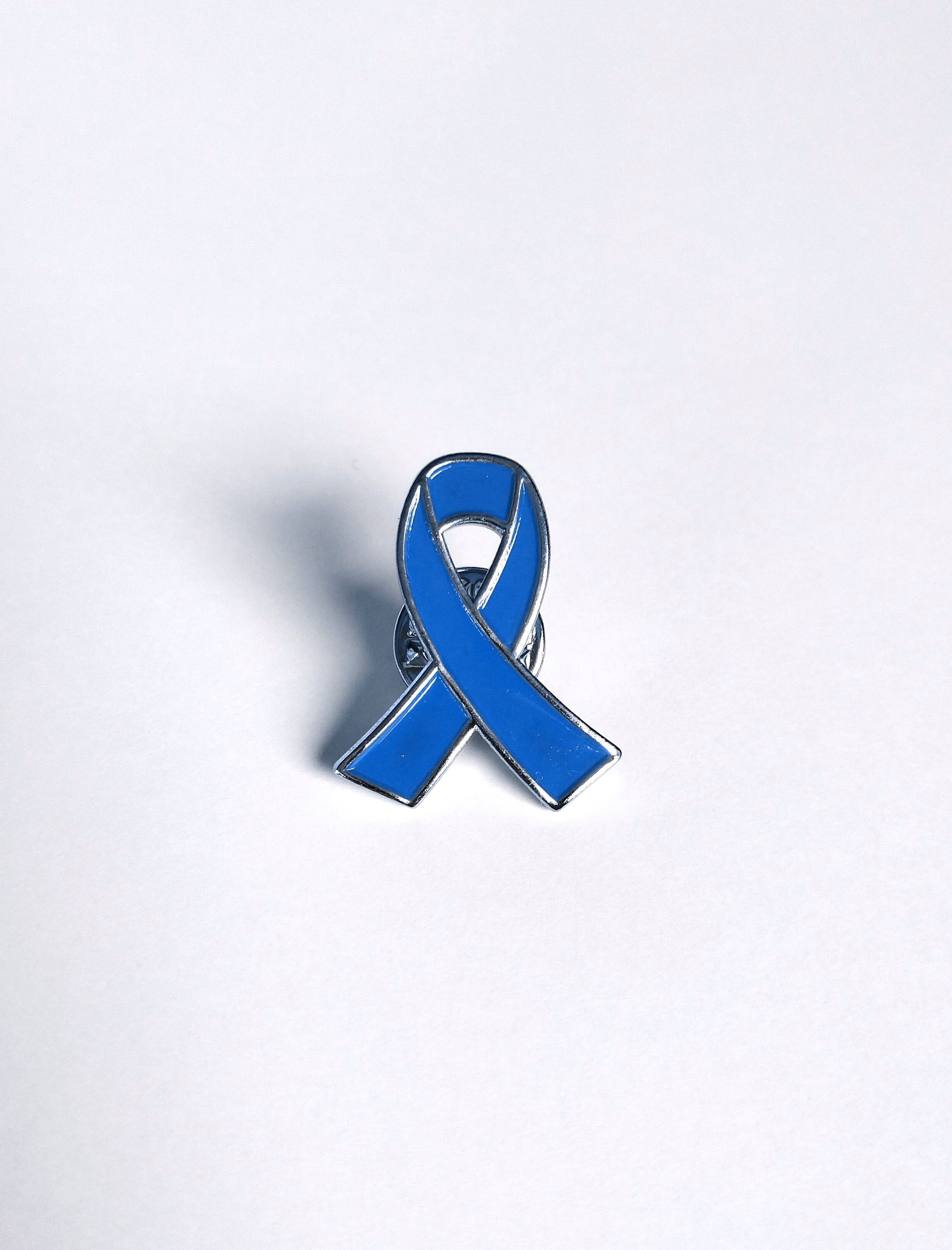 Pin's de sensibilisation en métal couleur argent et émail bleu représentant un ruban bleu, symbole de la fibromyalgie.