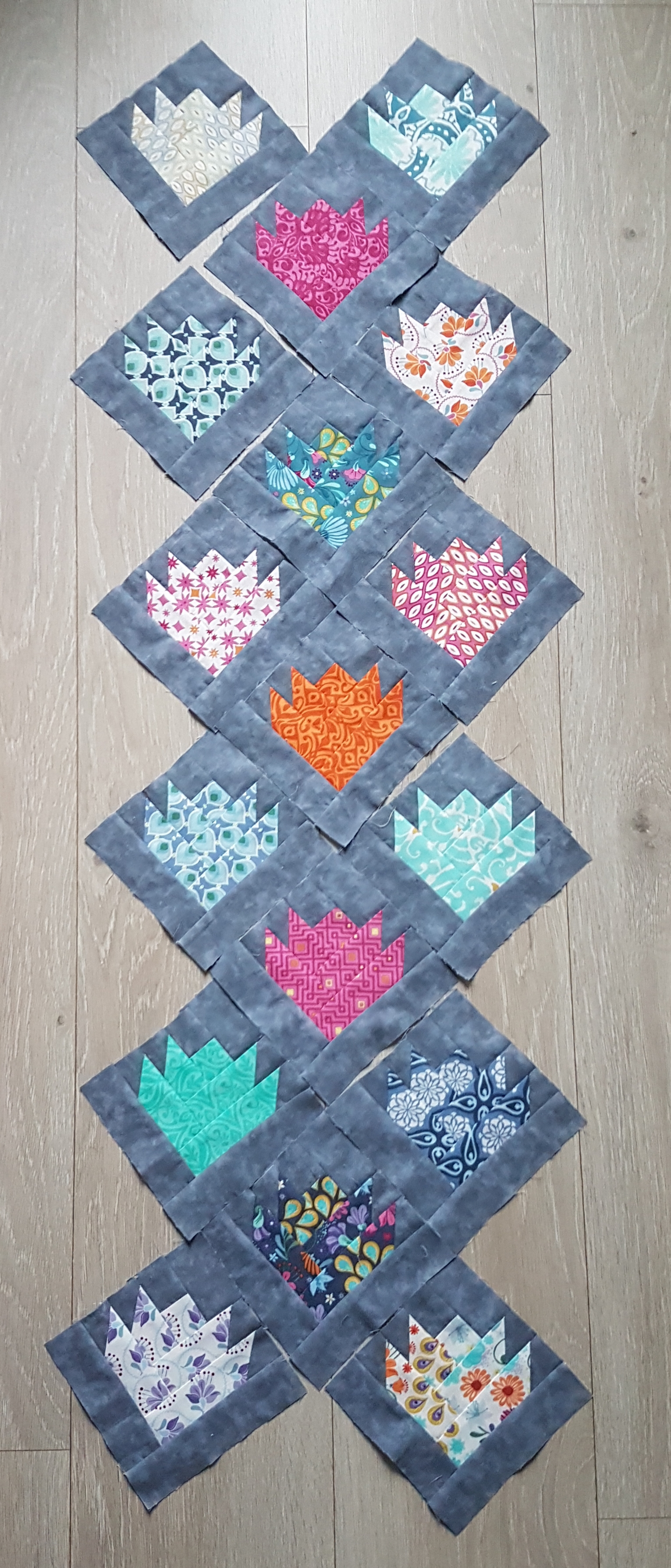 Frühling : Chaque motif est composé de plusieurs petites pièces multicolores que je vais assortir en harmonisant les couleurs, puis les assembler entre elles dans un log-cabin excentré. Suivra le matelassage, puis le quilting  dans l'esprit de ce chemin de table.