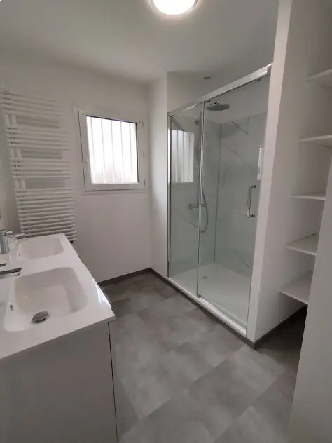 Création d'une salle de bain avec douche italiennne, séche serviette, meuble double vasque et des panneaux dans la douche à Nantes
