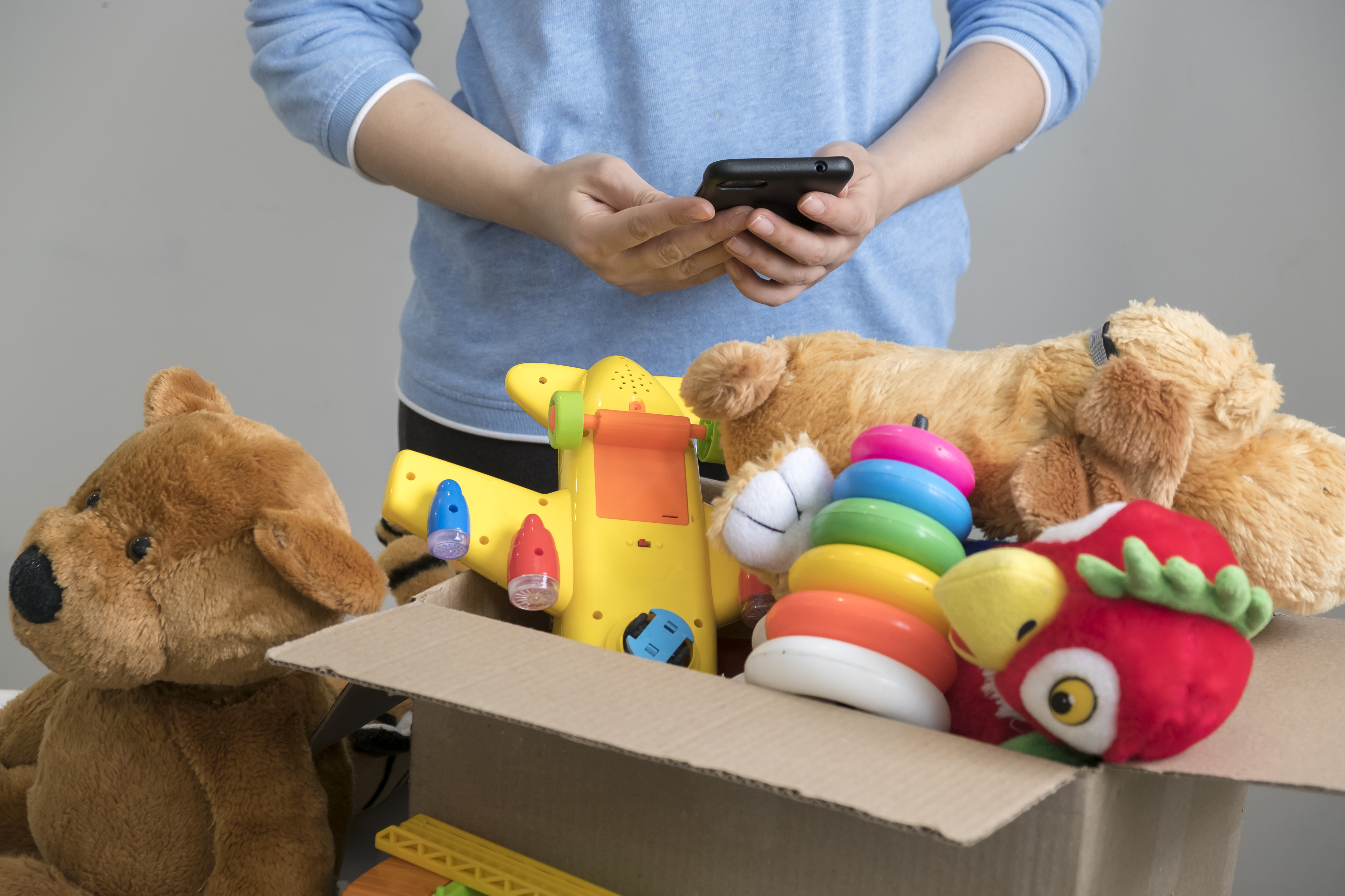 Benevole-tenant-une-boite-de-dons-avec-de-vieux-jouets