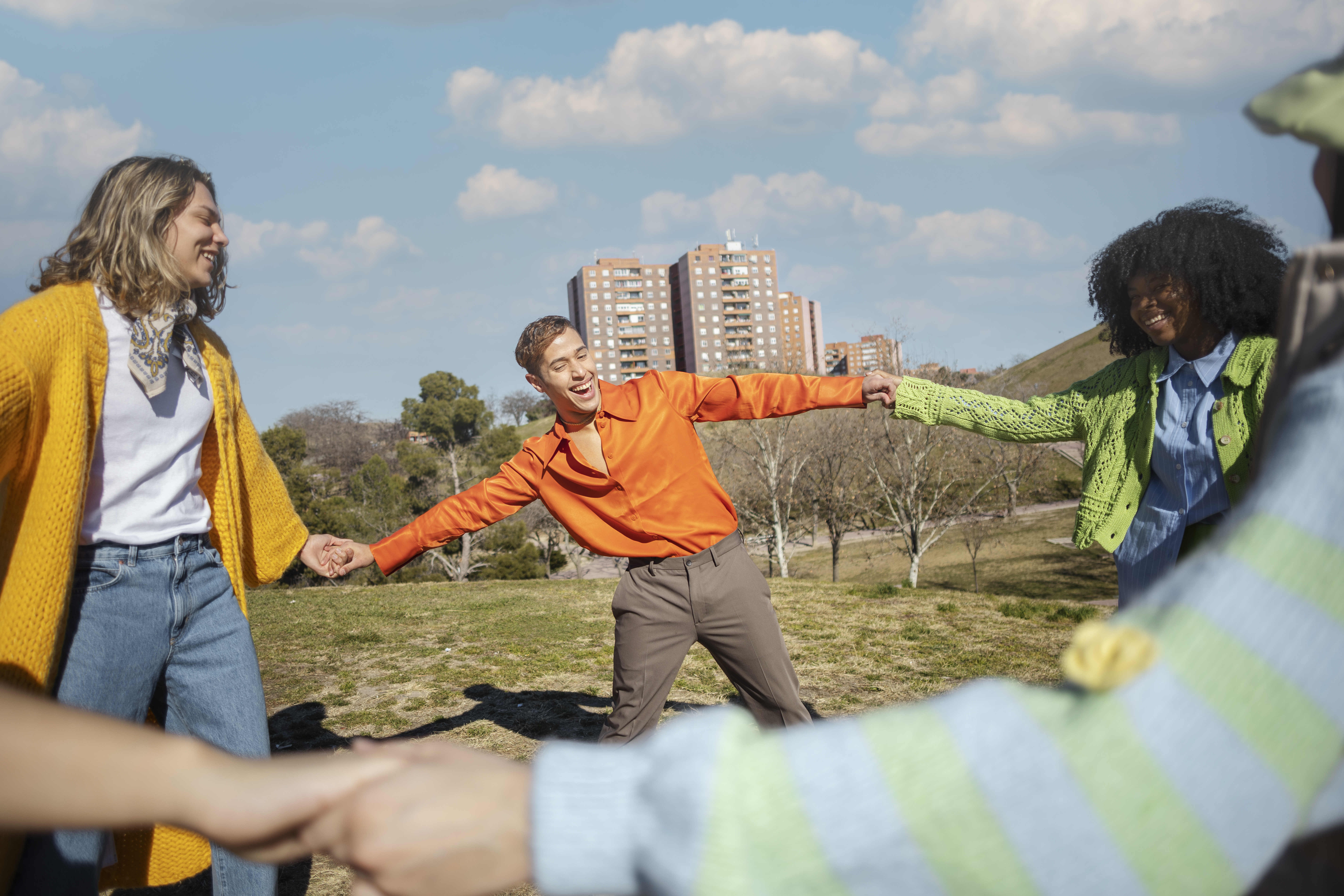 Amis-tournant-et-se-tenant-la-main-dans-un-champ-exterieur
