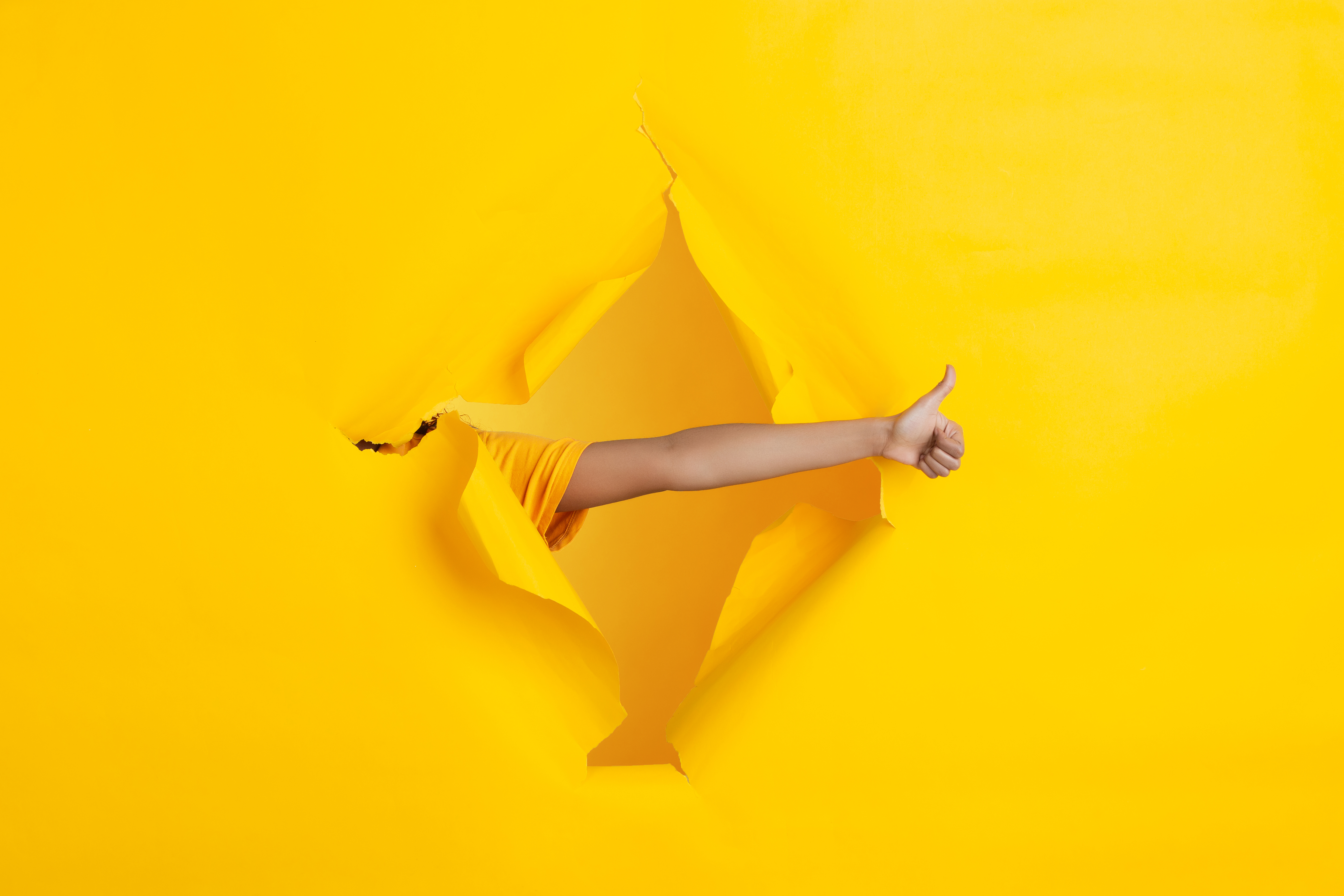 Female-hand-pointing-showing-torn-yellow-paper-hole-background-breaking-breakthrought-with-gesturing-concept-celebration-shopping-proposal-sales-ad-copyspace-promotions-discounts
