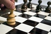 8531906 man hand moving queen on chess table