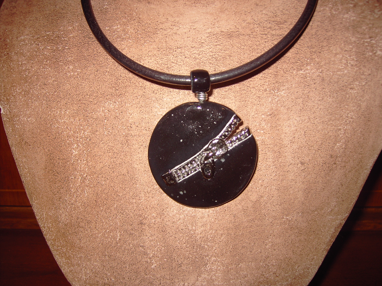 Pendentif en pocelaine noir et platine sur jonc de cuir