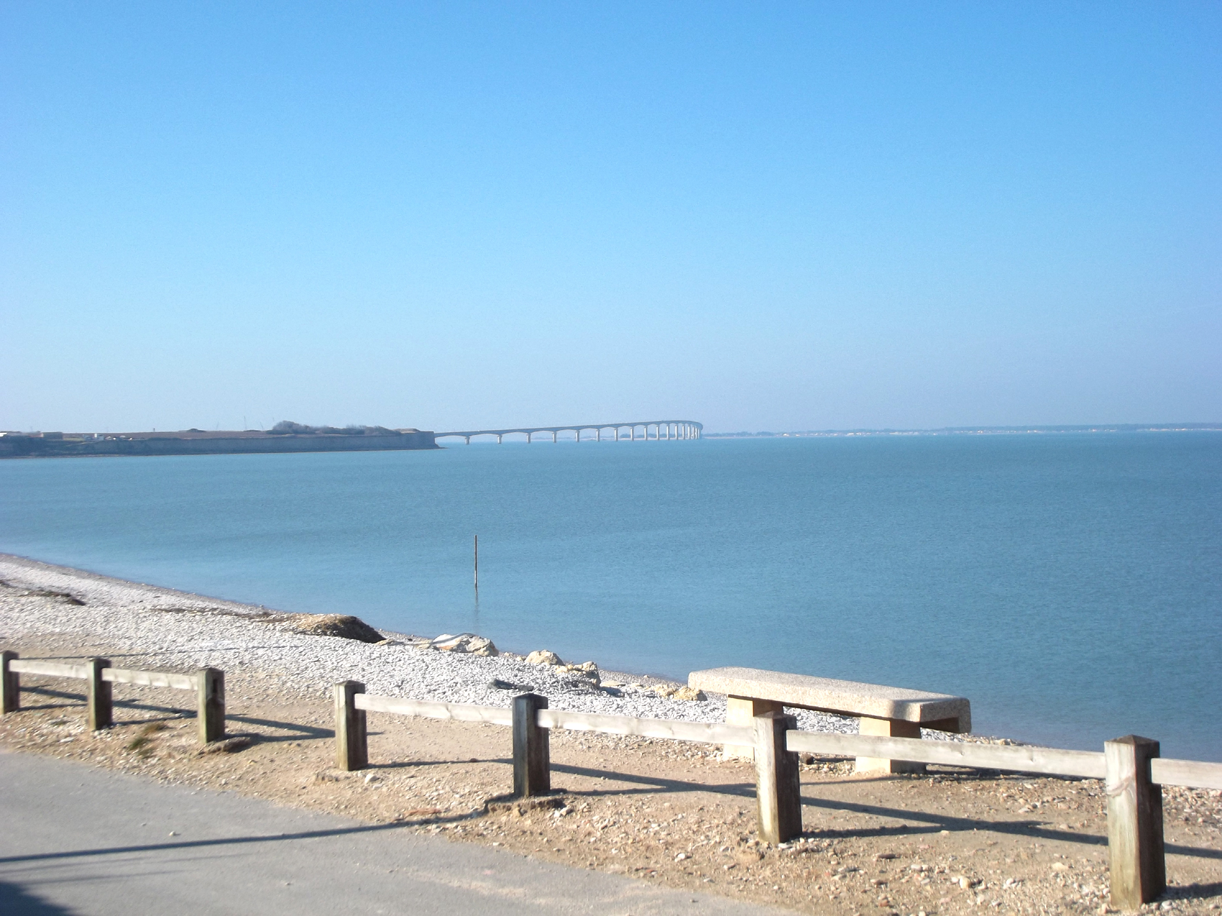La plage de galets avec en arrière plan le pont de l'île de ré