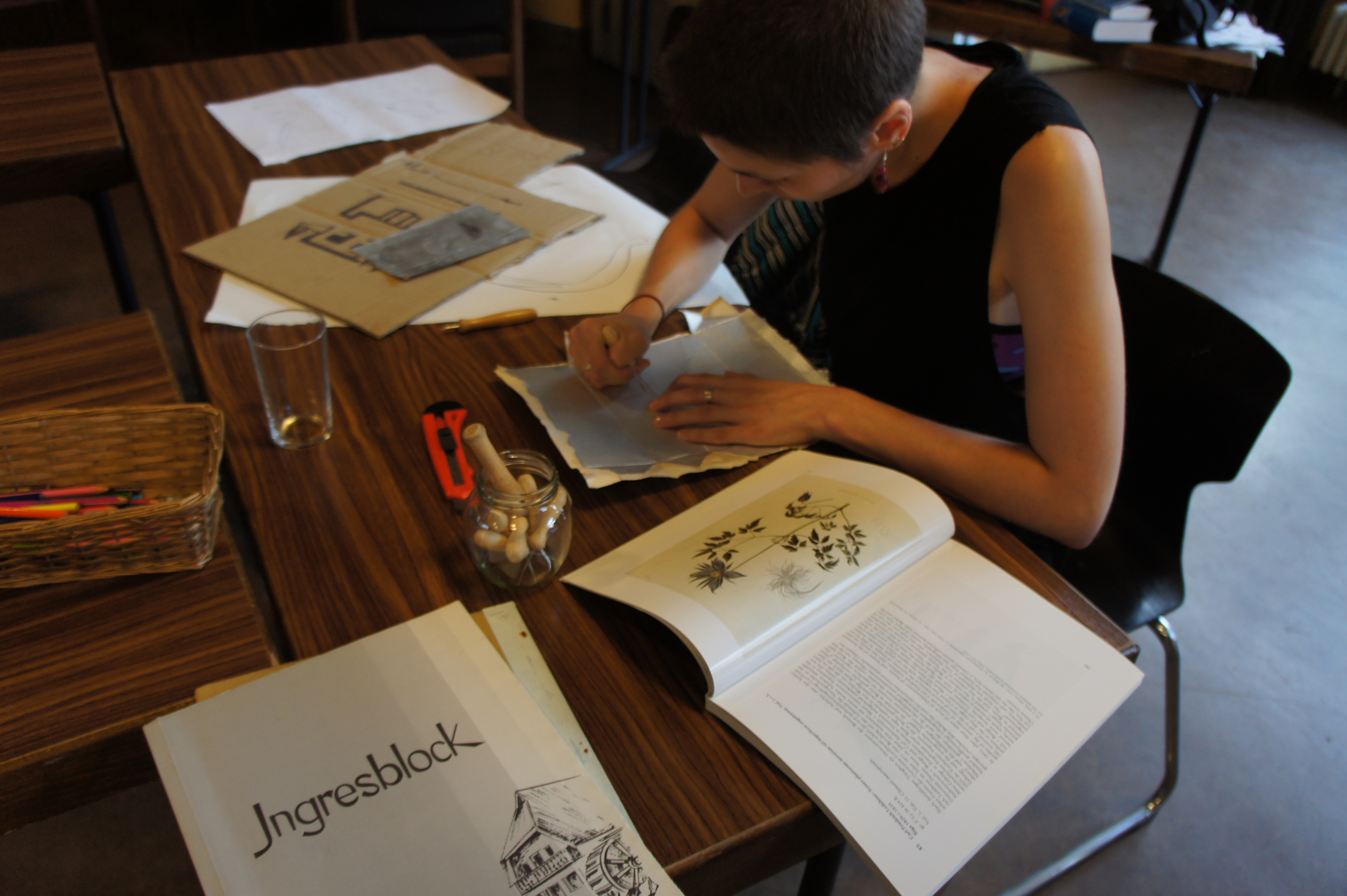 Marina grave un motif floral sur la partie aluminium d'une boîte de lait.