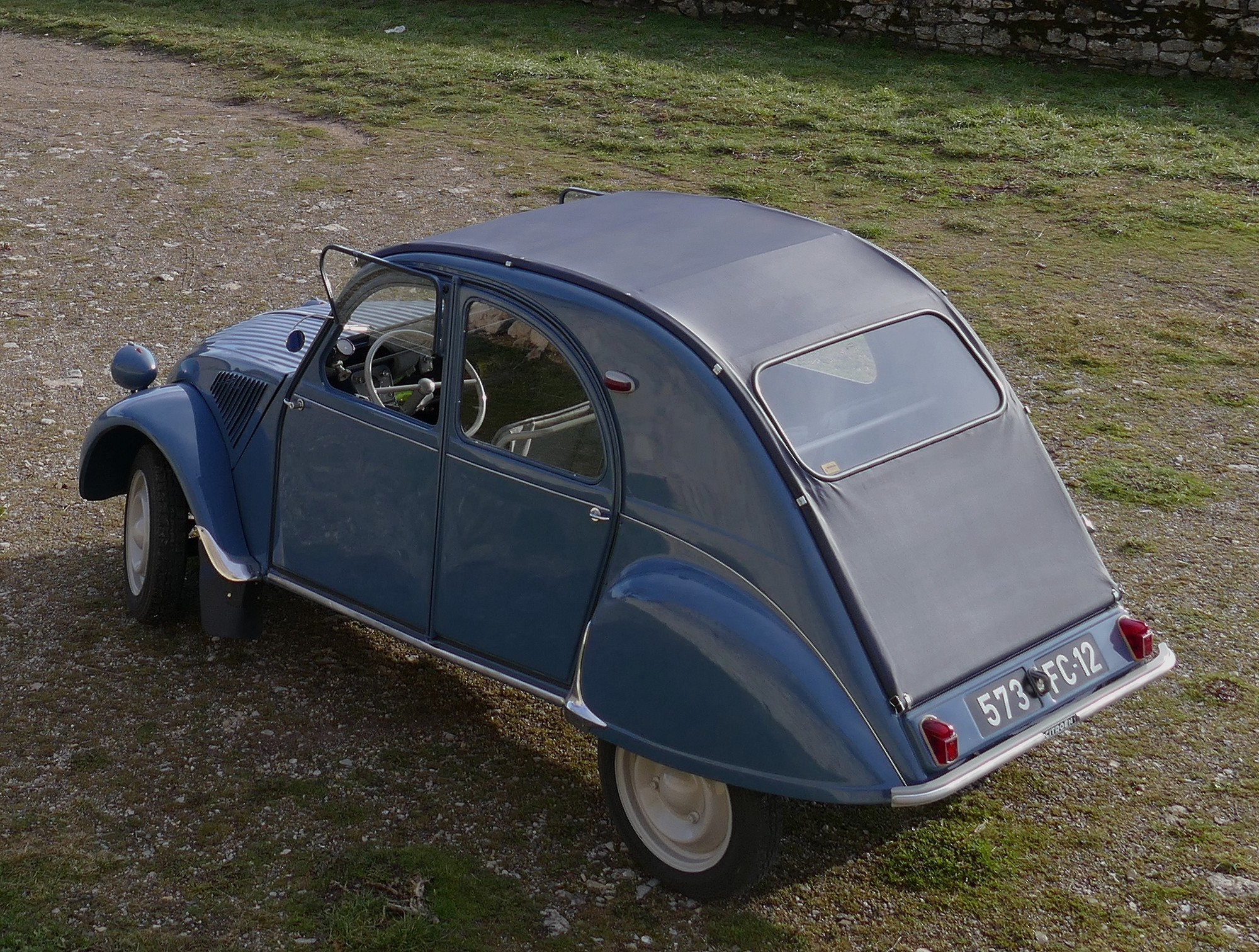 Citroën 2cv AZL avec sa capote longue et sa caisse en Couleur "Bleu glacier Ac 606" comme à l'origine.
Dès septembre 1957 Citroën adopte pour tous les Types de 2CV une jupe arrière identique à deux médaillons emboutis avec éclairage central.
Ce panneau arrière peut recevoir indifféremment une capote longue de plus en plus rare (2cv AZL) ou une capote courte avec une porte de malle fermant à clé : ce modèle étant de plus en plus plébiscité par les acheteurs citadins (2cv AZLP).