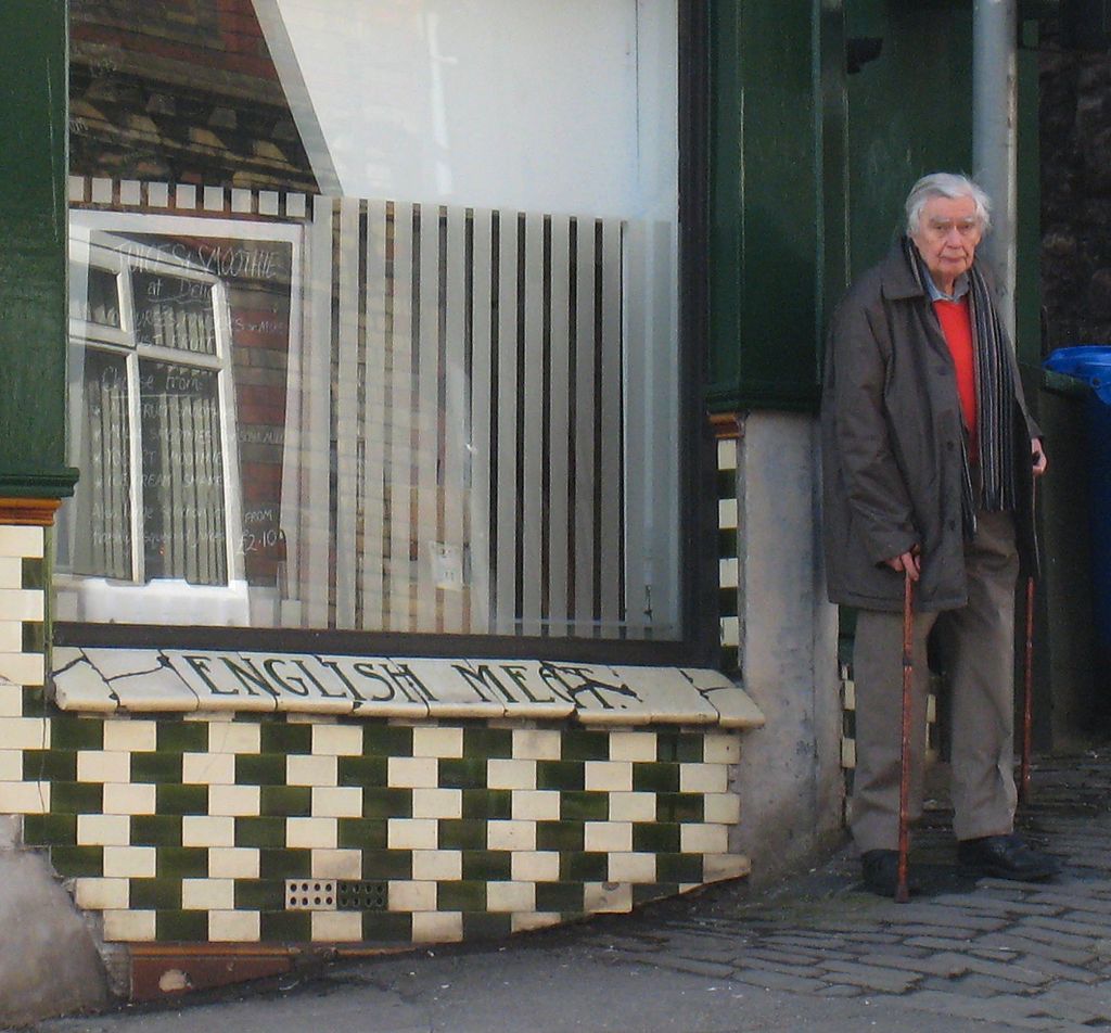 Le Professeur Richard Gregory devant la façade d'un bâtiment décorée sur le même principe que celle du mur de Café