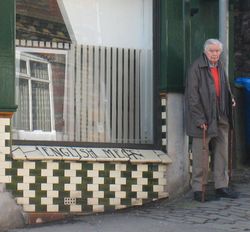 Le Professeur Richard Gregory devant la façade d'un bâtiment décorée sur le même principe que celle du mur de Café