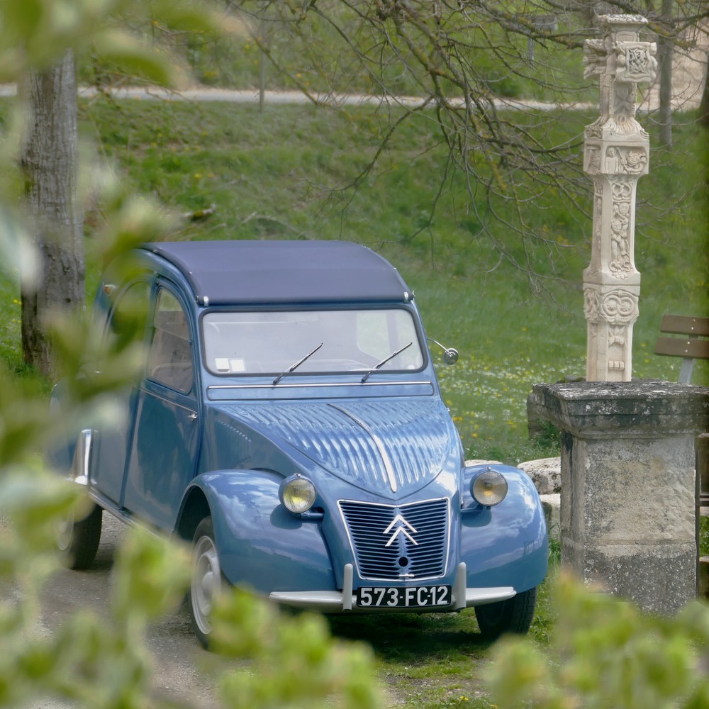 2cv AZL en visite chez Les amis de Saint-Austremoine devant la croix de Saint-Austremoine sculptée par Henri Duffourg artiste aveyronnais.
