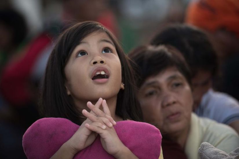 565402 une petite fille a tacloban aux philippines regarde atterrir un helicoptere a bord duquel elle esper