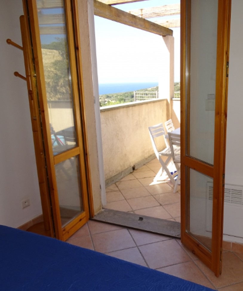 Photo prise assis sur le lit, chambre donnant sur la terrasse