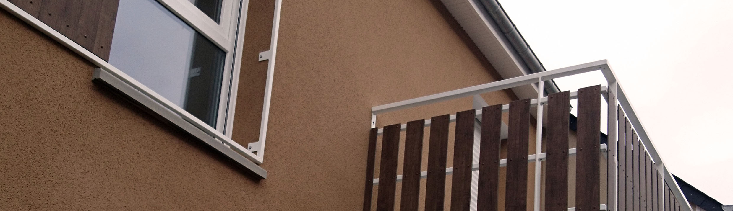 3 logements hlm à carentan en zone inondable réalisés pour manche habitat. les garde-corps sont réalisés en hpl fundermax 0803 tyrol pine