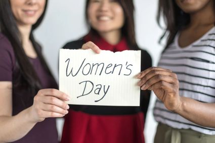 Three women stand together celebrating women s day