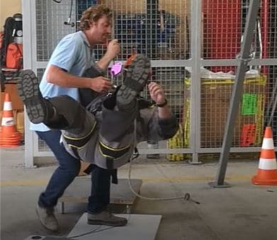 Formateur aidant un salarié lors de l'atelier chute de plain pied en entreprise- safety day