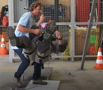 Formateur aidant un salarié lors de l'atelier chute de plain pied en entreprise- safety day