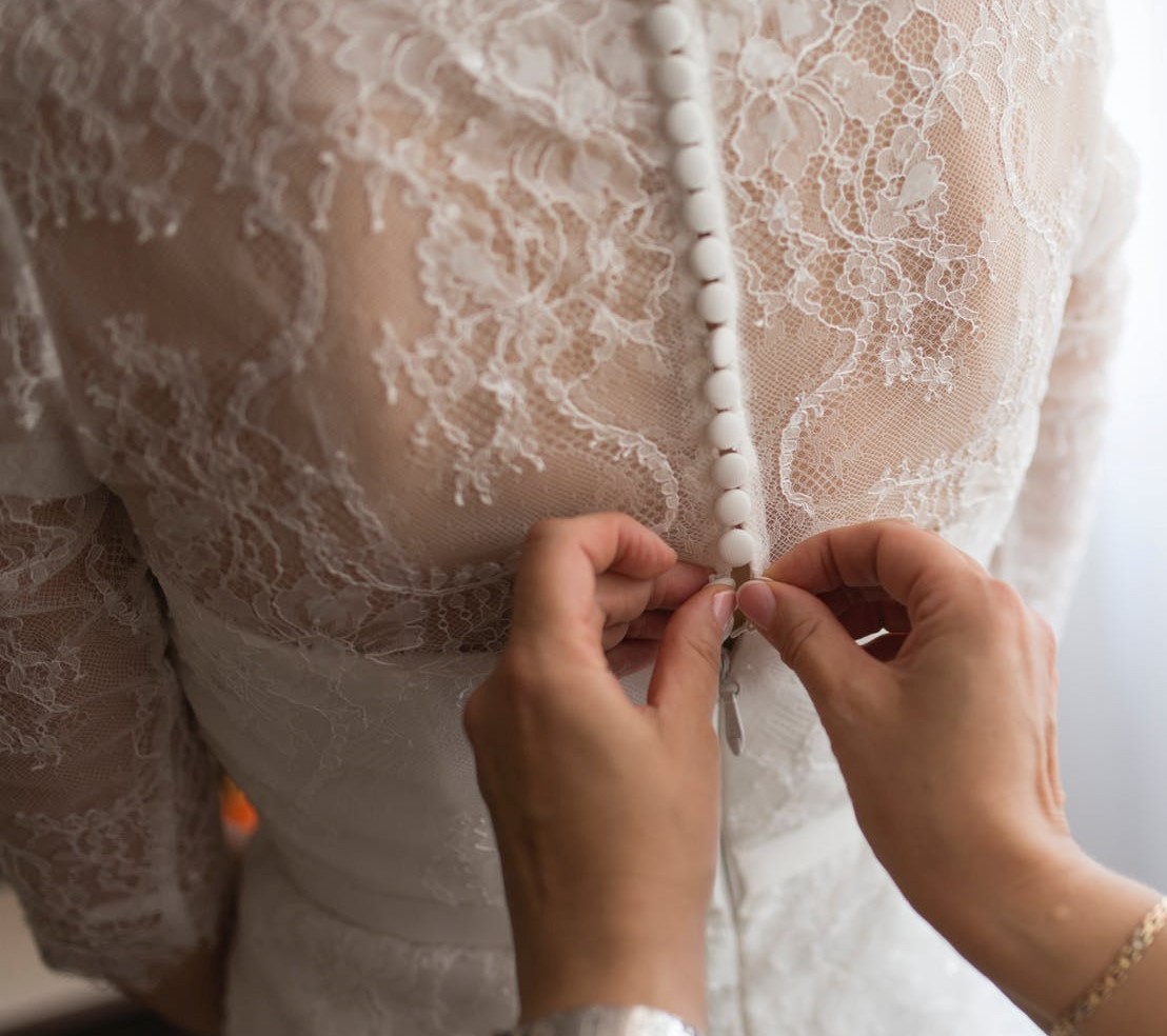 Habillage robe de mariée blanche en dentelle avec bonton en satin