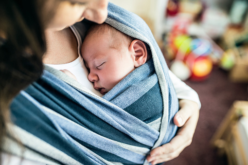 Unrecognizable young mother with her son in sling picture id614209062