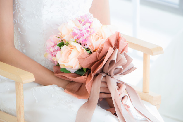 Femme portant robe mariee est assise chaise tient bouquet fleurs pour se preparer seance photo avant mariage 71793 213