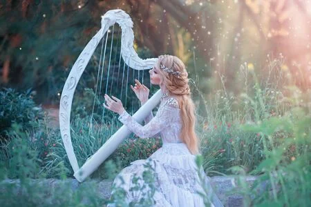 125567885-une-mysterieuse-nymphe-de-la-foret-joue-sur-une-harpe-blanche-dans-un-endroit-fabuleux-une-fille-aux