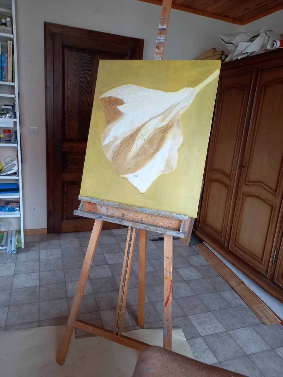 Tableau couleur jaune et brun sur chevalet. Fond: gris et brun