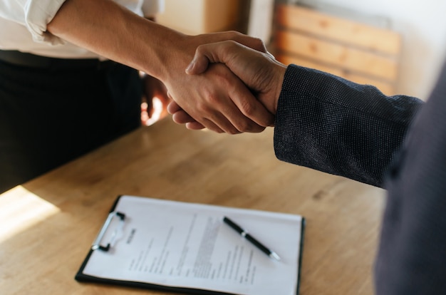 Partenariat-poignee-main-deux-hommes-affaires-apres-signature-du-contrat-travail-au-bureau-salle-reunion 33829-185
