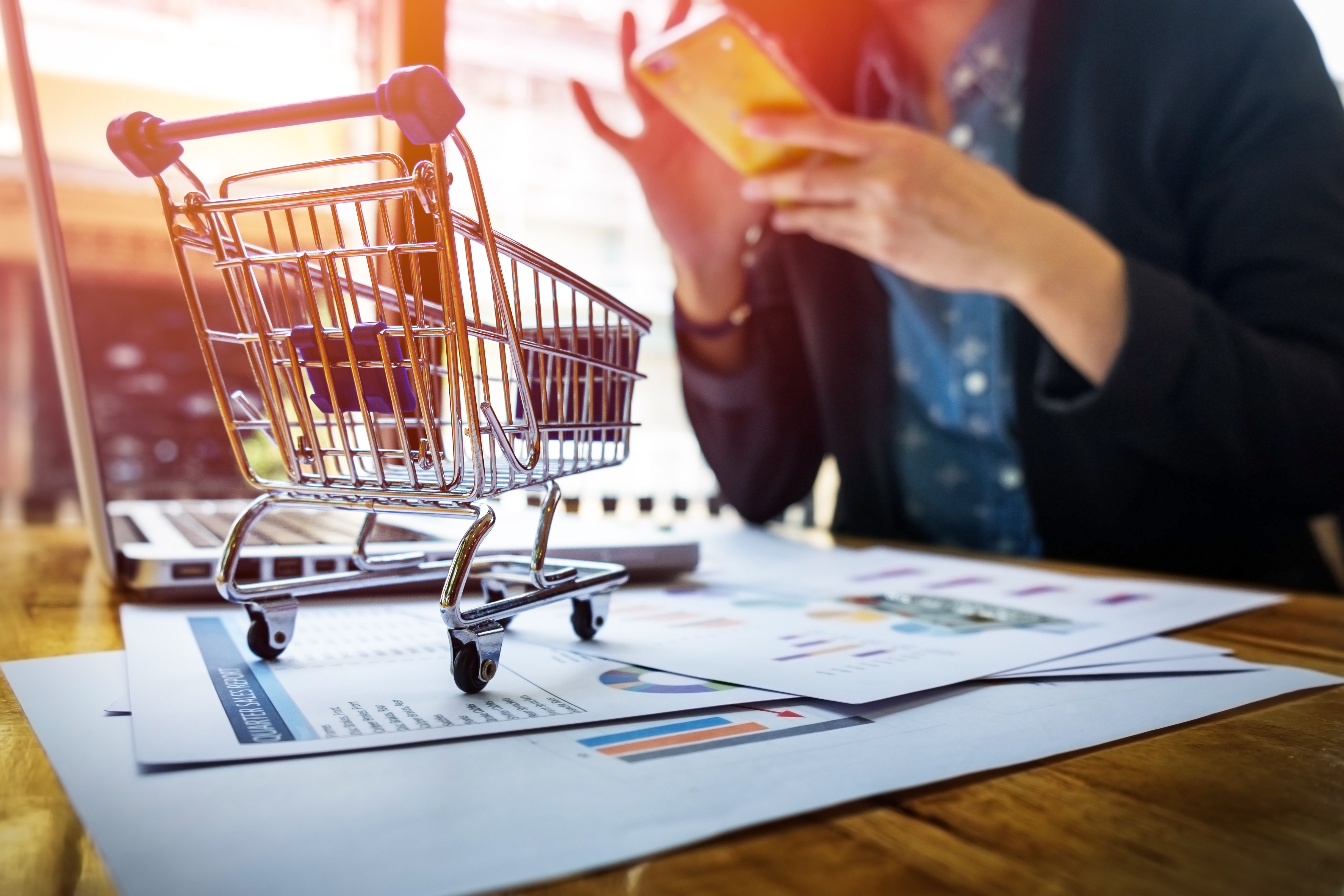 Cropped-image-woman-inputting-card-information-key-phone-laptop-while-shopping-online