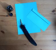 feuilles et enveloppe bleues, plume et encre pour écrire des lettres personnalisées aux mamans solo entrepreneures.