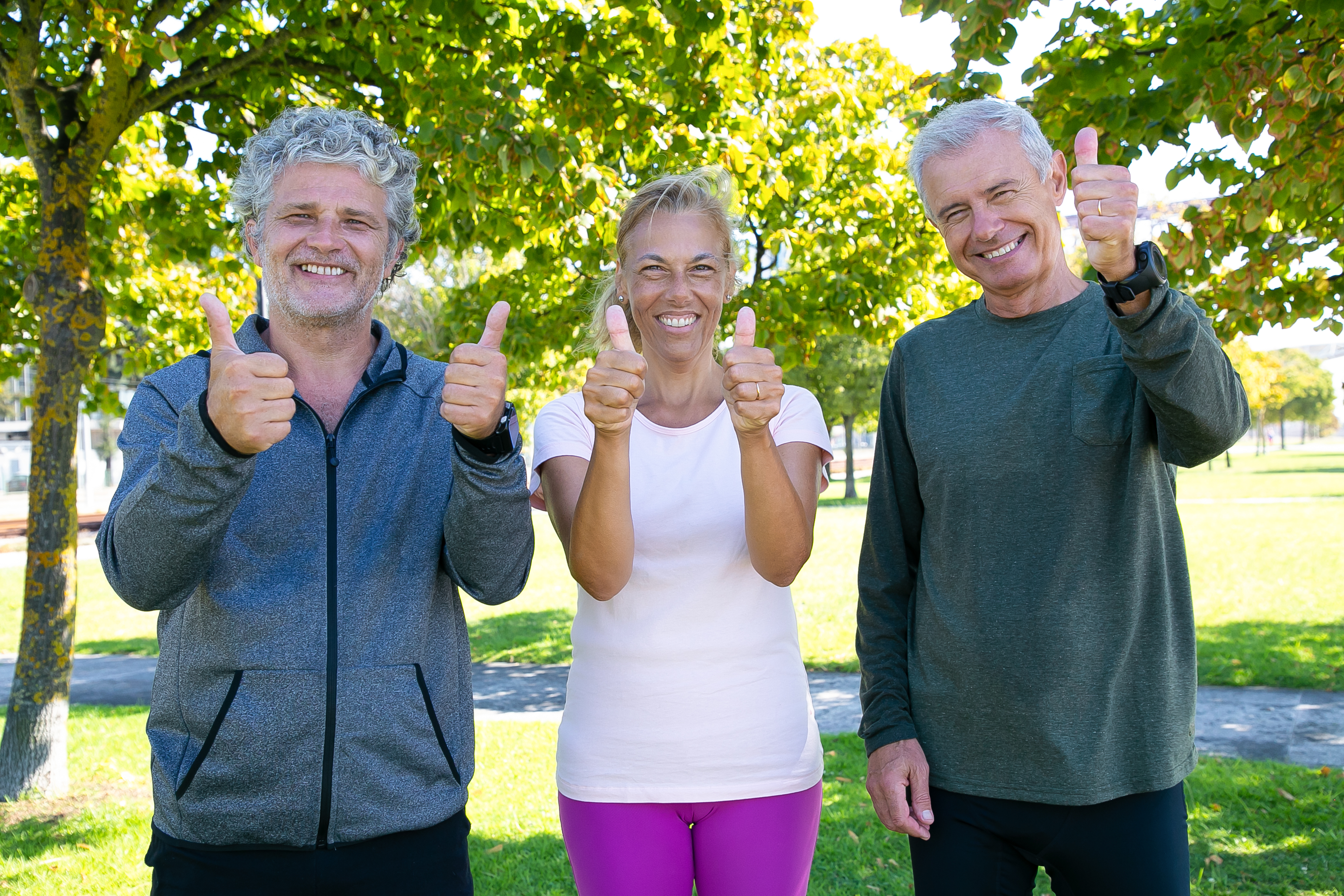 Gens-matures-sportifs-gais-debout-ensemble-apres-exercices-du-matin-dans-parc-souriant-montrant-pouces-vers-haut-concept-retraite-mode-vie-actif
