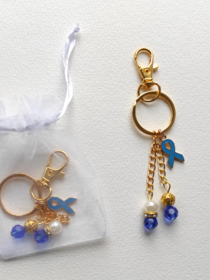 Porte-clé de sensibilisation en métal couleur or avec breloques perles et ruban bleu, symbole de la fibromyalgie.