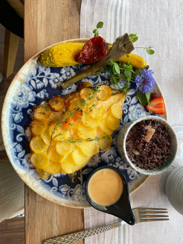 Filet de turbot en écailles de pommes de terre et son beurre de mandarine riz vénéré légumes de saisons bio et locaux et fleurs comestibles