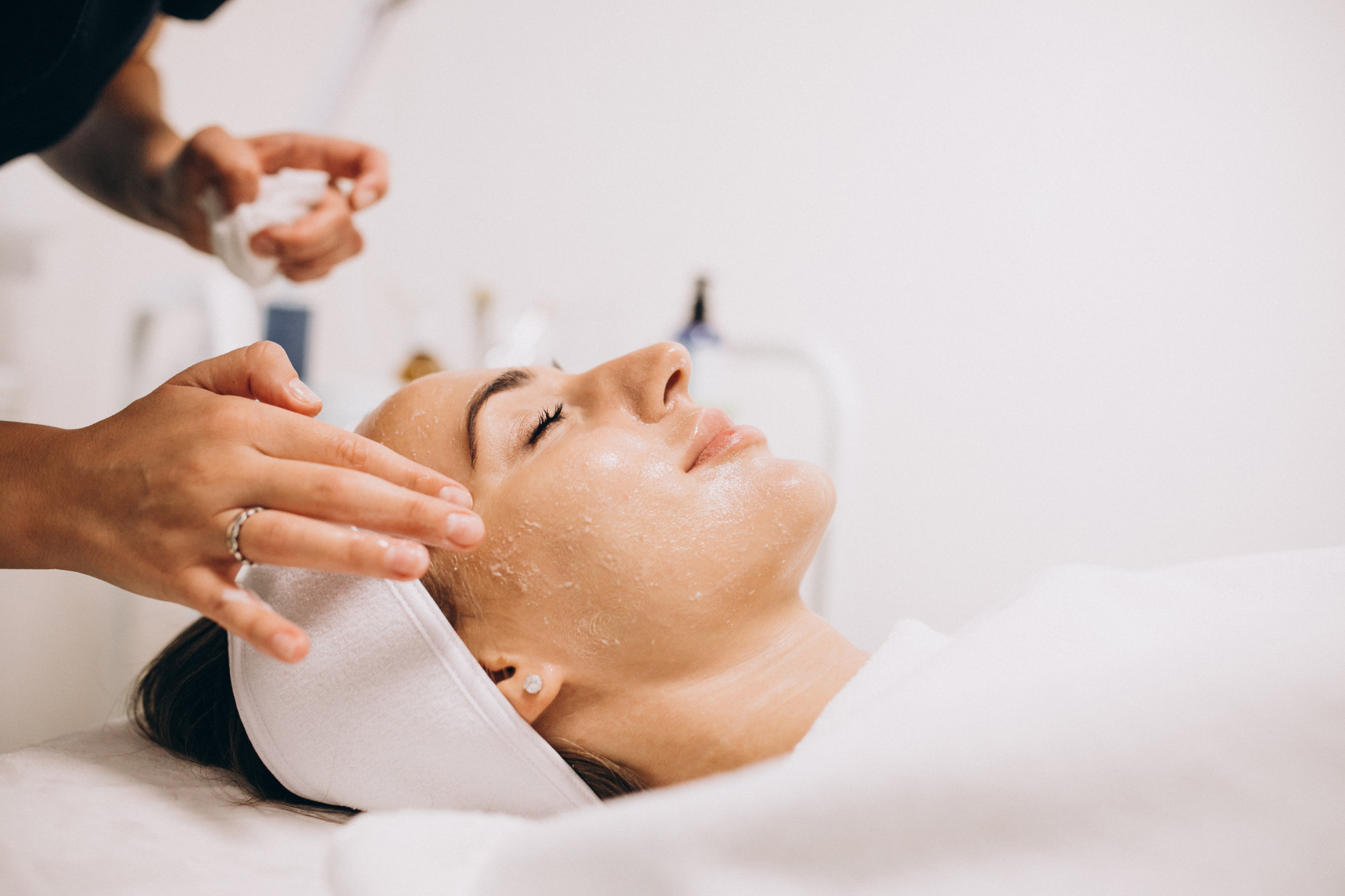 Cosmetologist-cleaning-face-woman-beauty-salon