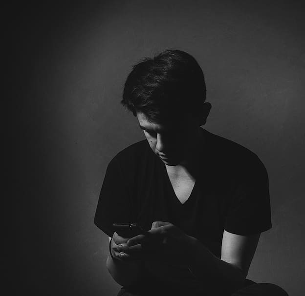 Photo en noir et blanc d'un enfant sur son smartphone
