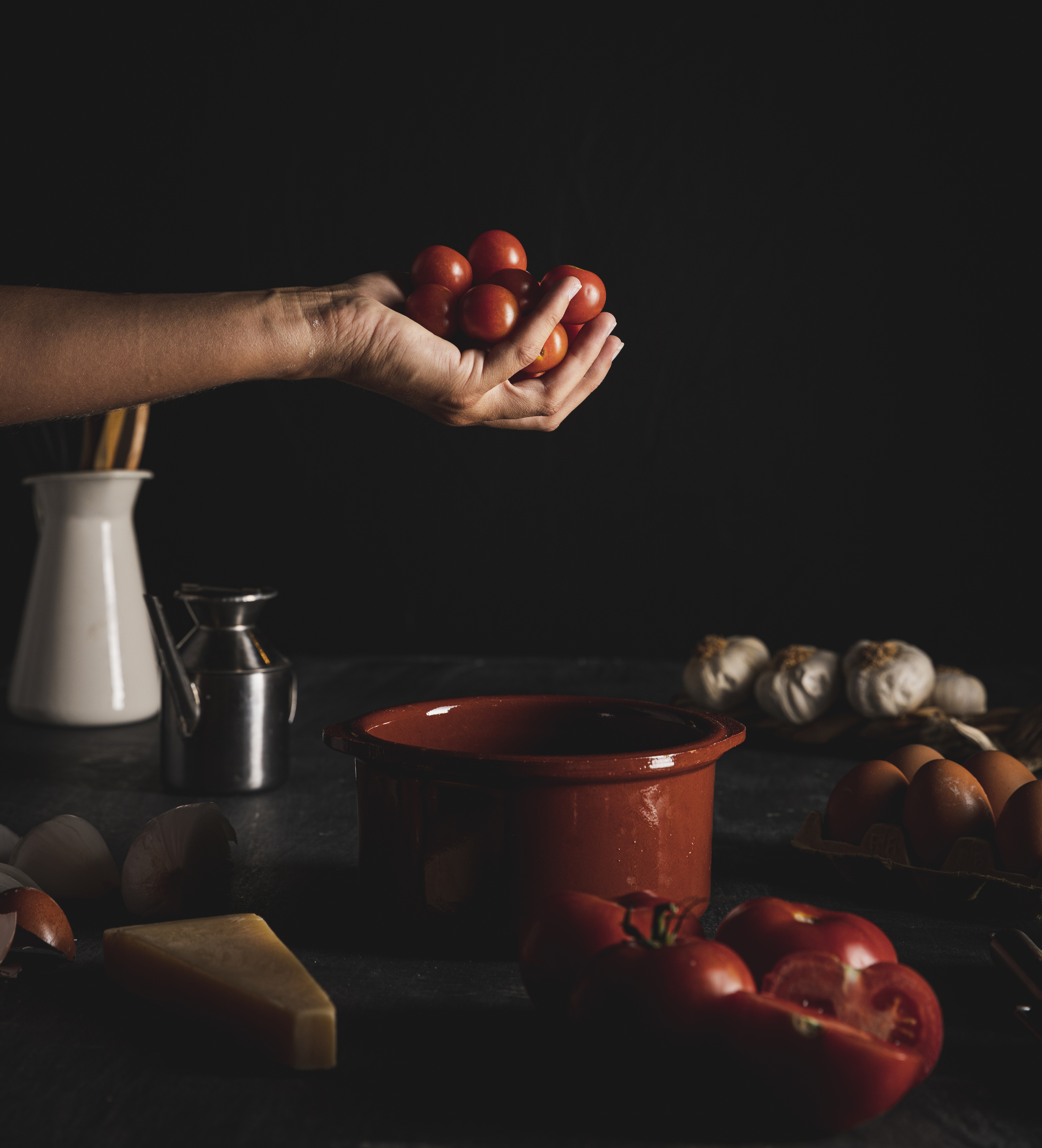 Close up person holding tomatoes with dark background