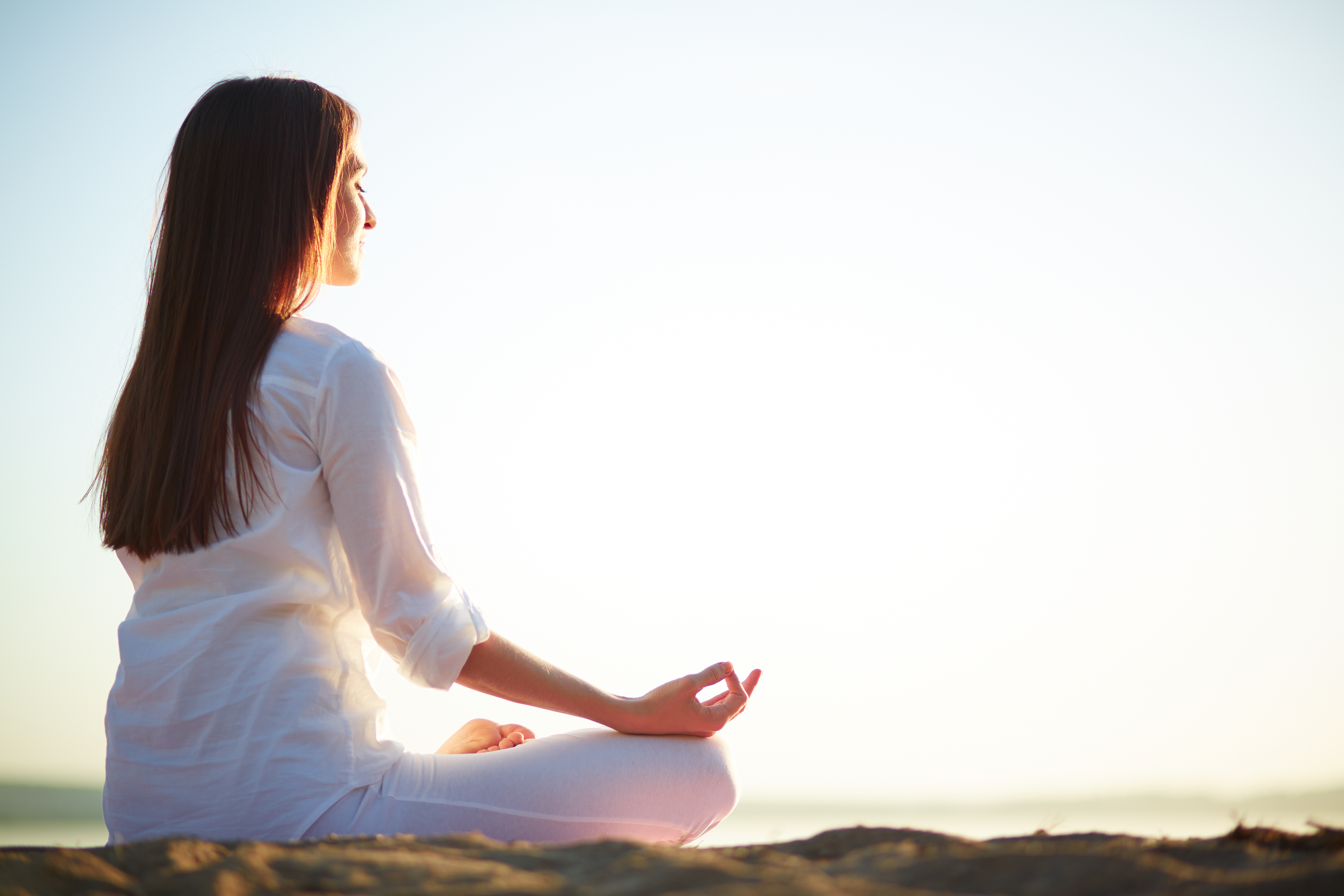 Woman sitting yoga pose beach