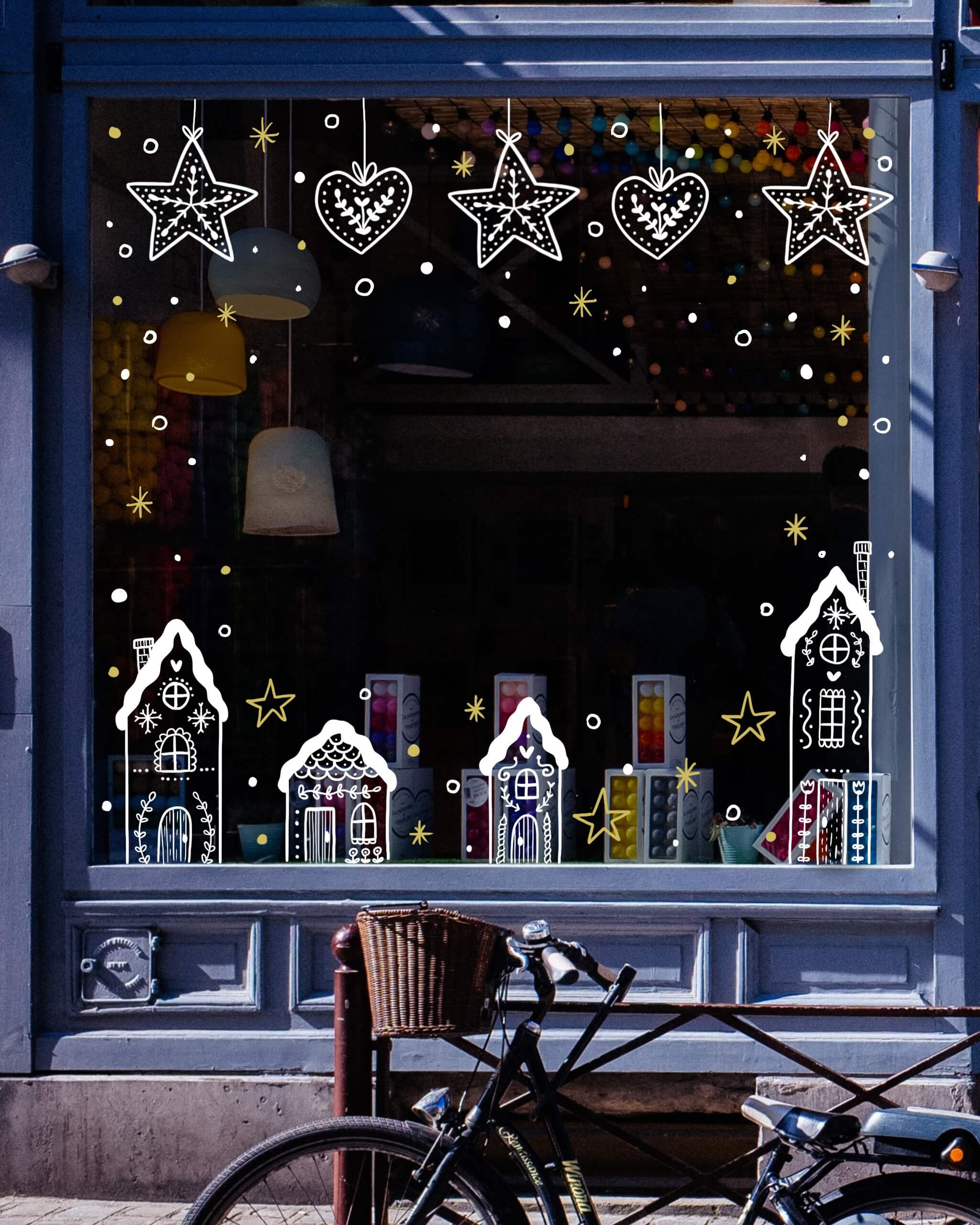 Vitrine peinte sur le thème de Noël avec des maison en pain d'épices et des flocons de neige, à Paris ou dans les Yvelines