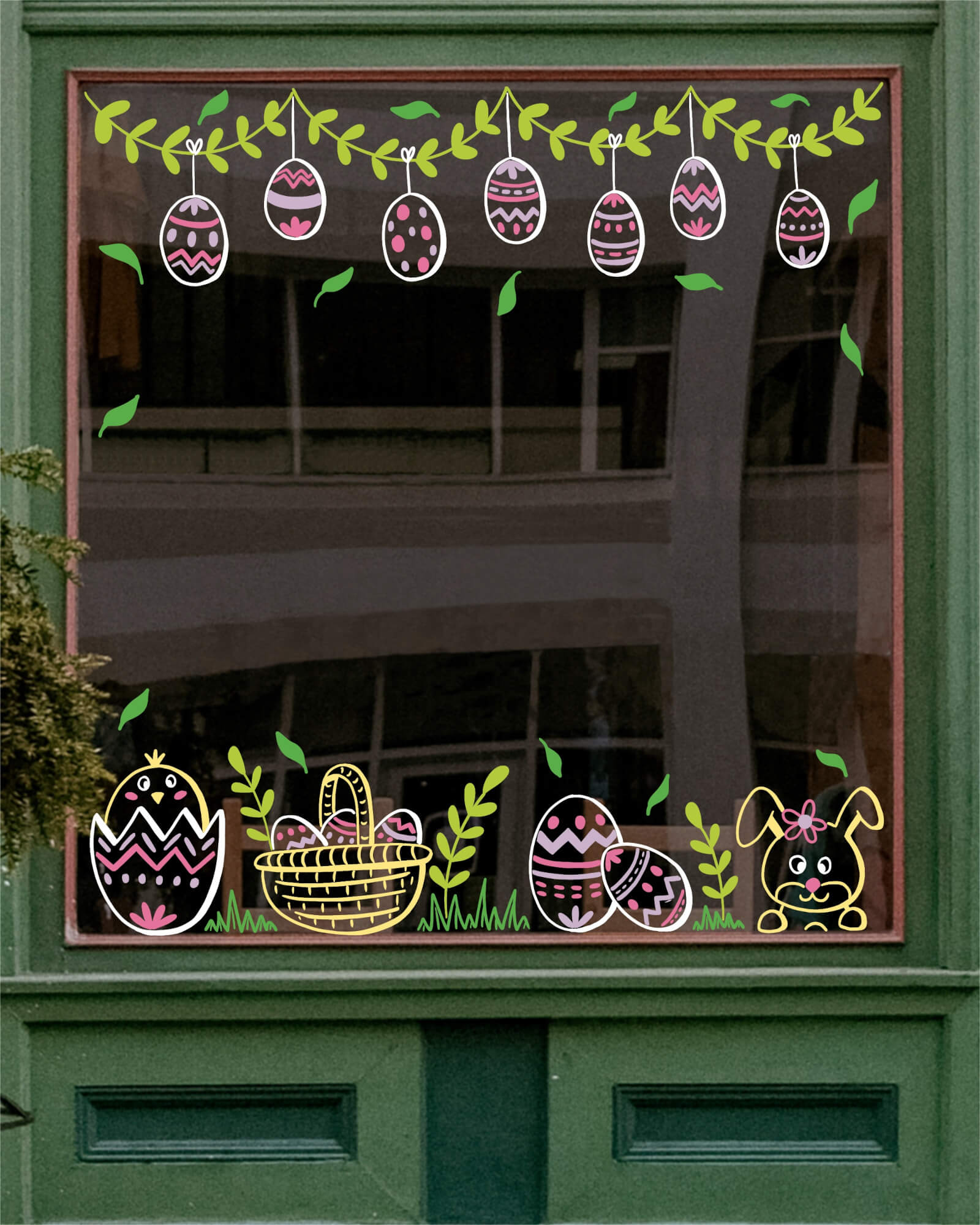 Peinture sur vitrine à Paris ou dans les Yvelines représentant un décor de Pâques avec des oeufs de Pâques, un poussin, un lapin, un panier bien rempli et des décors végétaux