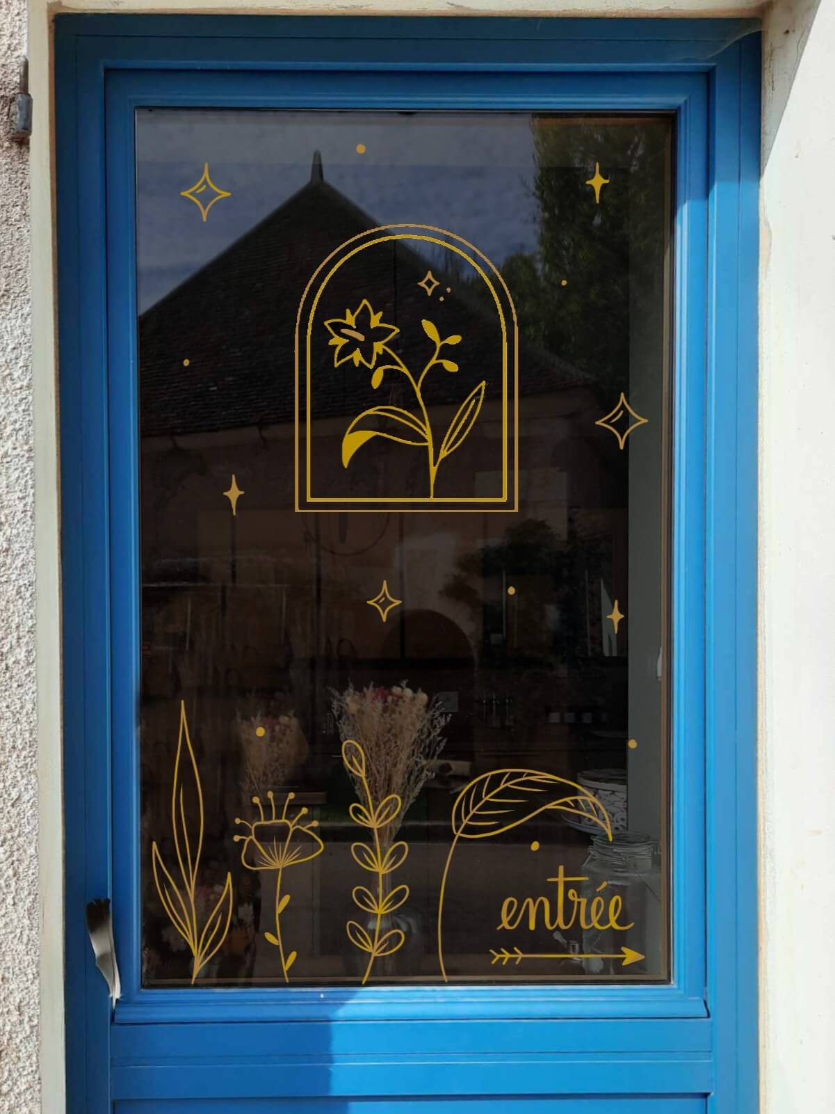 Peinture sur vitrine en doré pour une savonnerie dans le Morvan. Reprise du logo avec ajout d'éléments végétaux.