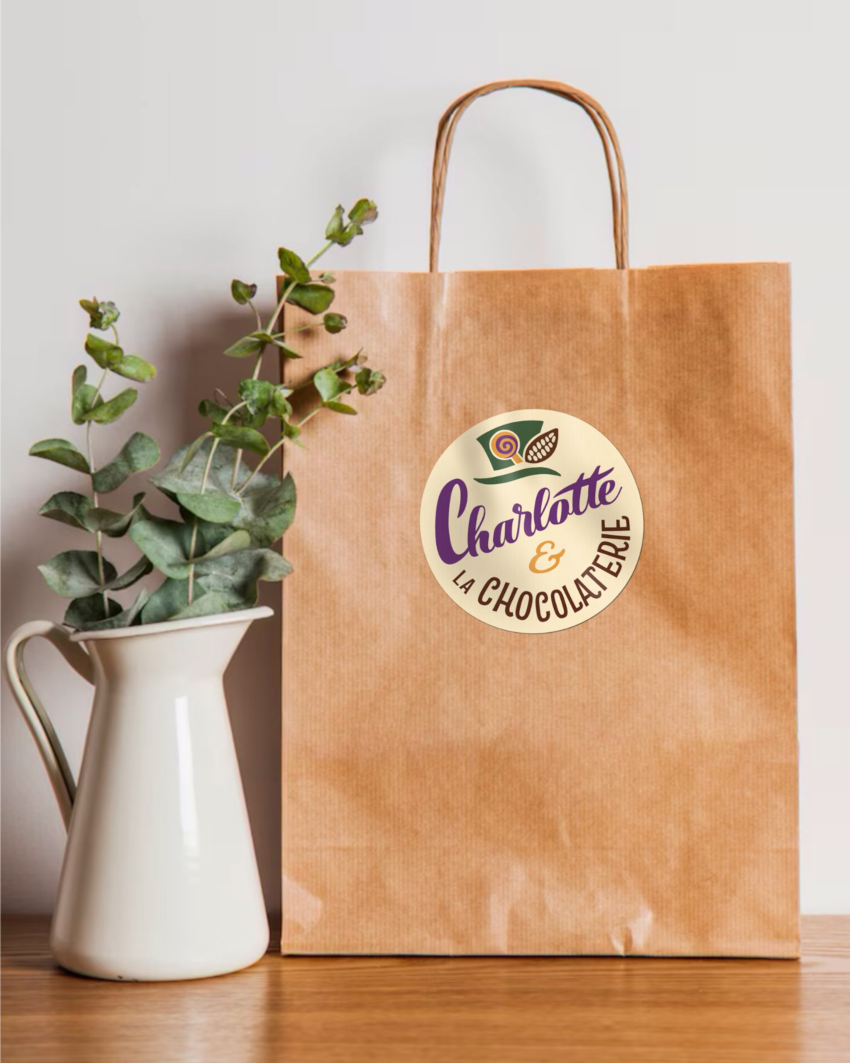 Maquette de sac kraft estampillé du logo de Charlotte et la Chocolaterie, logo créé par Camille F créations
