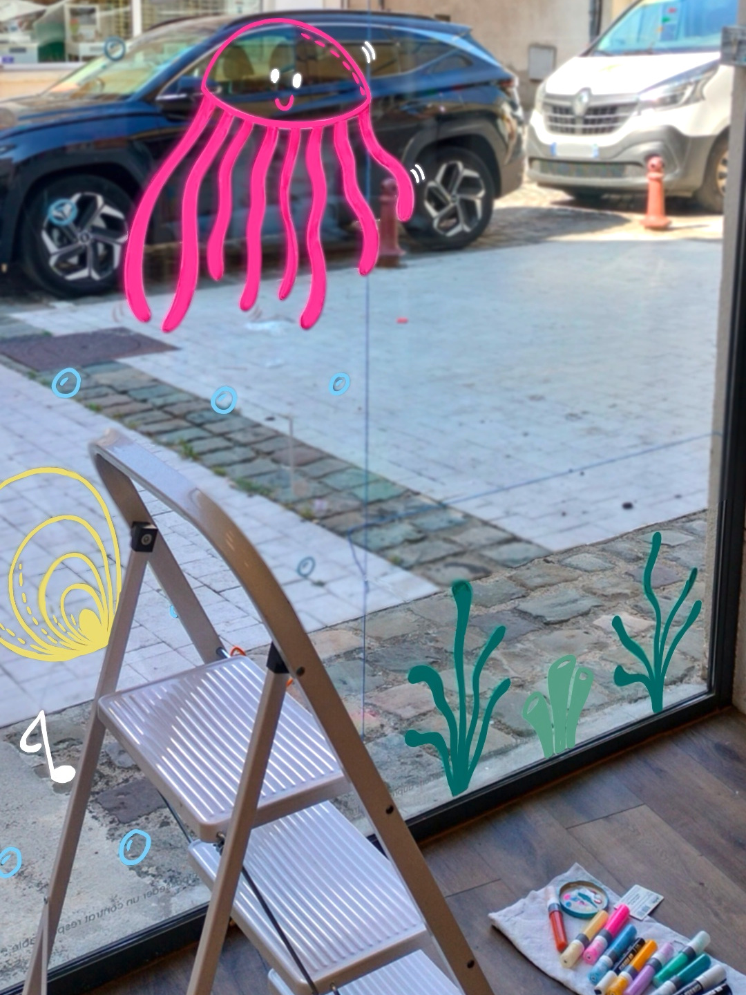 Peinture sur vitrine colorée sur le thème des coquillages à Dourdan (78)