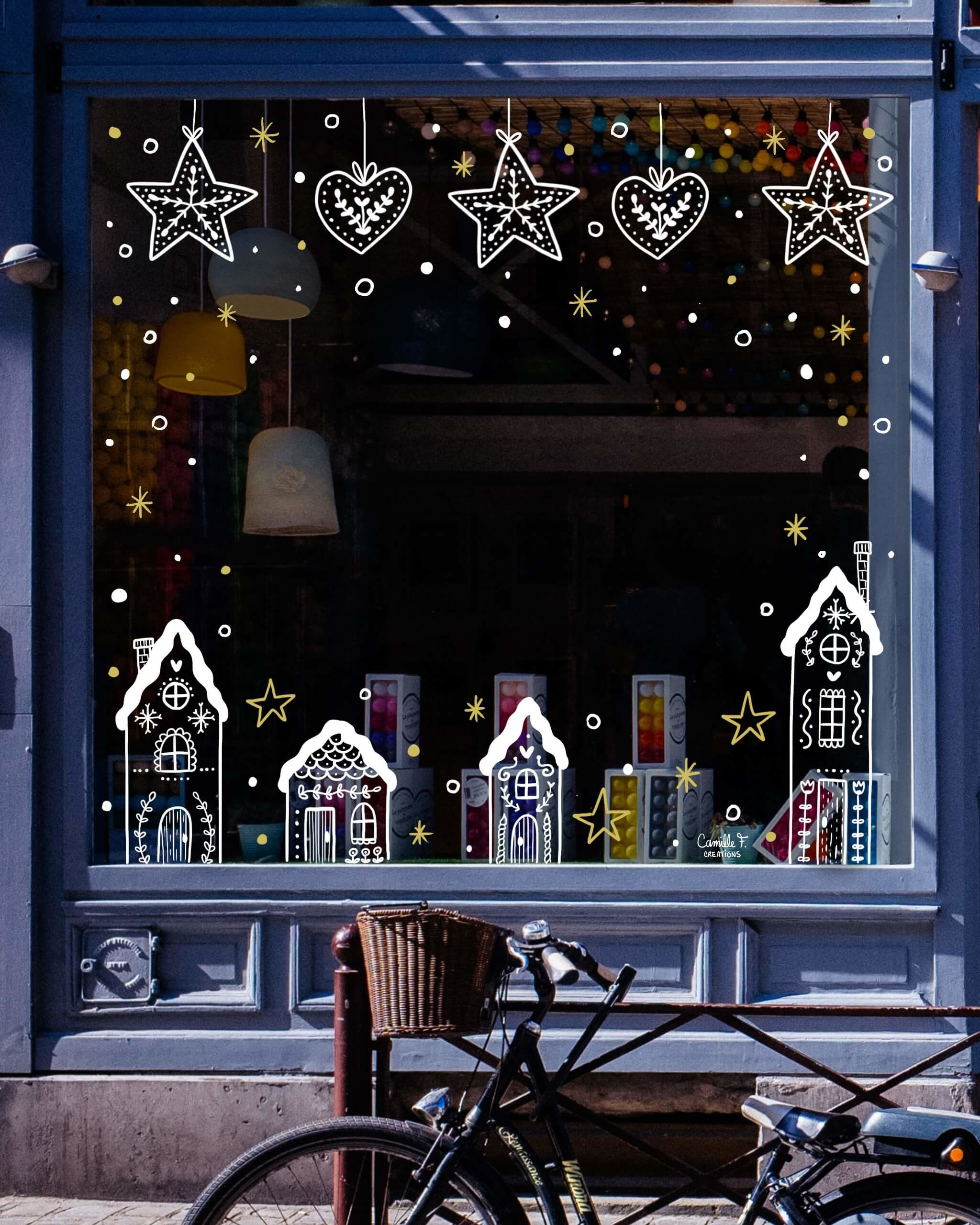 Peinture sur vitrine à Paris ou dans les Yvelines sur le thème de l'hiver ou de Noël, avec des maisons enneigées et des flocons de neige.