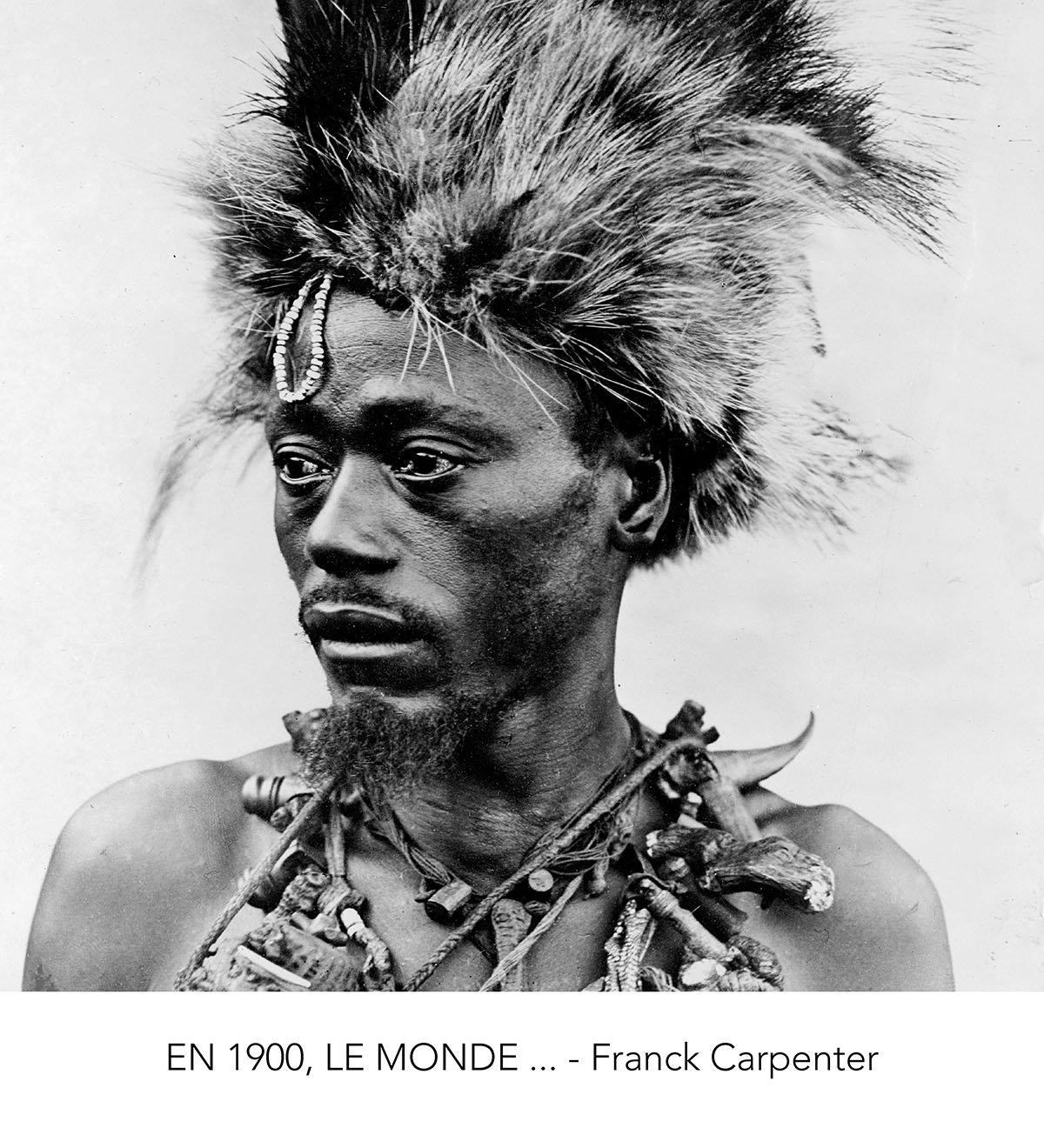 homme africain portant une coiffe traditionnelle ornée de plumes et divers ornements autour du cou, photographie prise vers 1900 par Franck Carpenter dans le cadre de son exploration du monde.